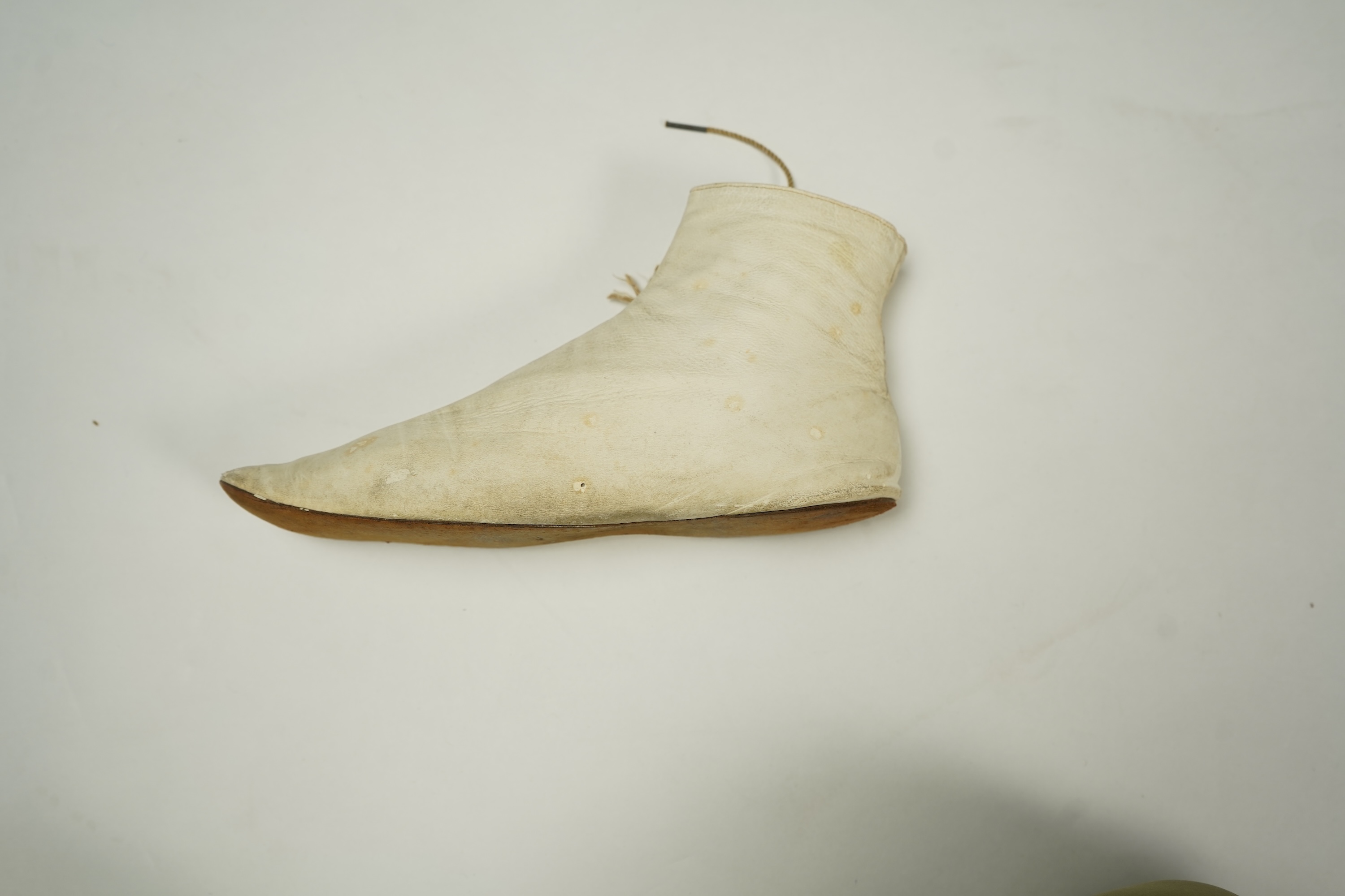 A 19th century hand made cream kid leather ladies ankle boot and four differing cream silk and satin single wedding shoes. All with leather soles. Possibly a traveller's sample range. Boots 24.5cm long (heel to toe). Con